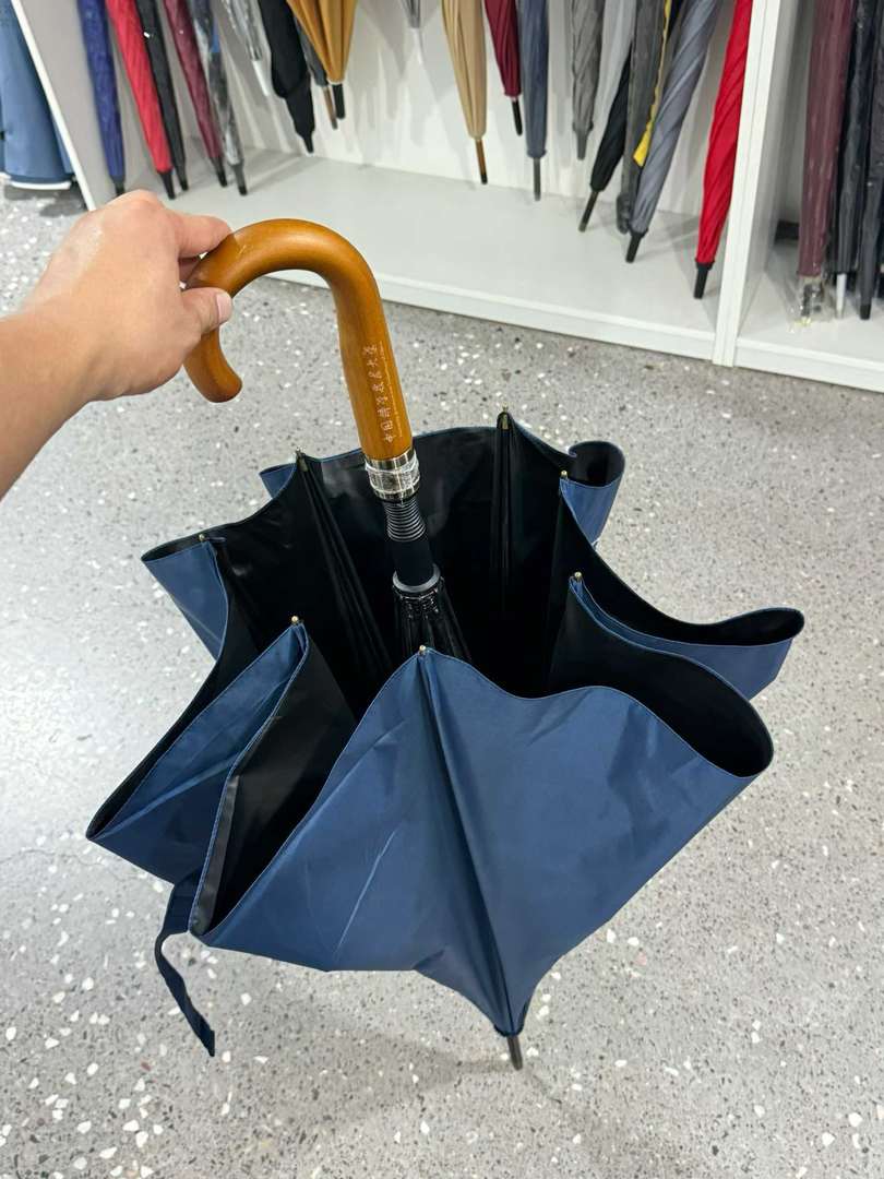USTC umbrella partly closed showing the handle and black underside